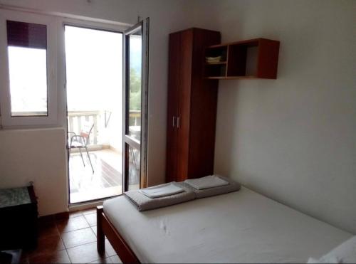 a bedroom with a bed and a large window at Apartment Željka, Igalo - Herceg Novi in Igalo