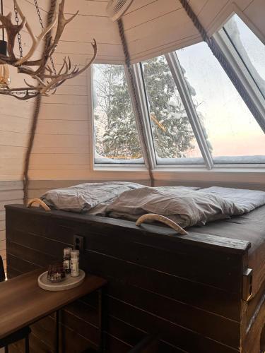 a bed in a room with two windows at Northernlight cabin 2 in Kiruna