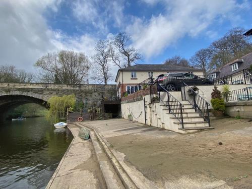 a bridge over a river with a car parked next to it at Luxury Home With Stunning River Views in Knaresborough