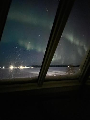 a view from a window of the ocean at night at Northernlight cabin 2 in Kiruna