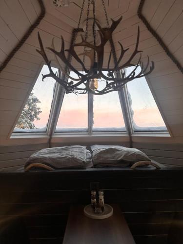 a window in a room with a bed and a chandelier at Northernlight cabin 2 in Kiruna