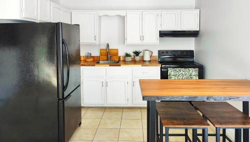 Fresh & Bright Private Suite في Lower Sackville: مطبخ مع دواليب بيضاء وثلاجة