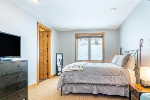 a bedroom with a bed and a flat screen tv at Ski in ski out Terraces Condo in Telluride