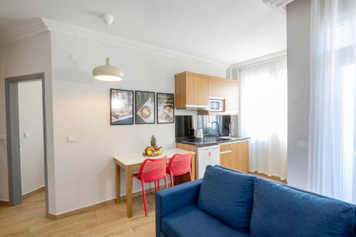 een woonkamer met een blauwe bank en een keuken bij Comfort Suites in Alanya
