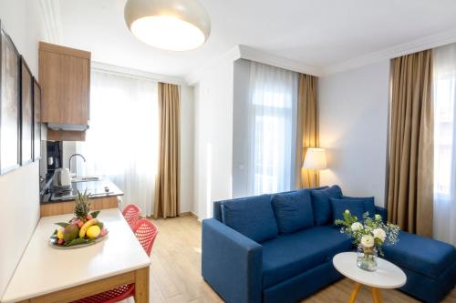 a living room with a blue couch and a table at Comfort Suites in Alanya