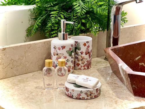 a bathroom with two bottles of soap and a sink at Charme 64 Hotel Boutique Aeropuerto in Cartagena de Indias