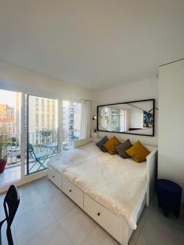 une chambre avec un grand lit avec une grande fenêtre dans l'établissement Cozy apartment with nice terrace, à Paris