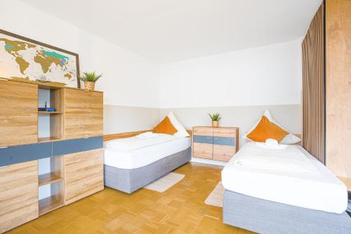 two beds in a room with wooden floors at Sleeping Home - Red House in Bielefeld