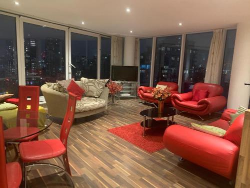 a living room with red chairs and couches at EXCEL STUNNING DUPLEX PENTHOUSE in London