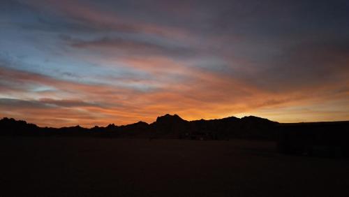 Hurghada Desert stargazing في الغردقة: غروب الشمس في الصحراء مع الجبال في الخلفية