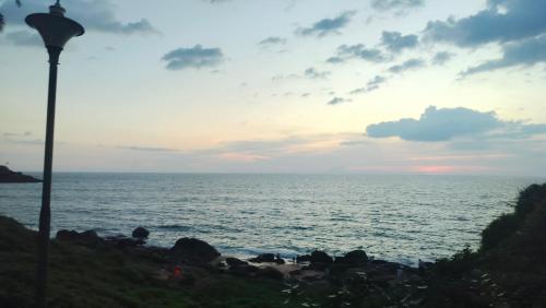 a street light next to the ocean at sunset at Banyan Tree Samudra in Kovalam