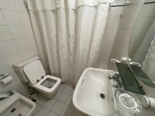 a white bathroom with a sink and a toilet at Beautiful apartment in Puerto Madero in Buenos Aires