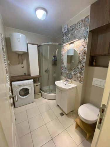 a bathroom with a toilet sink and a washing machine at Sunset Panorama in Sarajevo