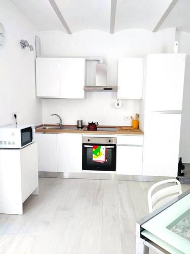 a white kitchen with white cabinets and an oven at Ambroeus Apartmens Casa Spaziosa in centro Paese in Inzago