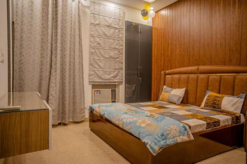 a bedroom with a bed and a large window at Rosset-57, Cosy Stay & luxury party place in Faridabad