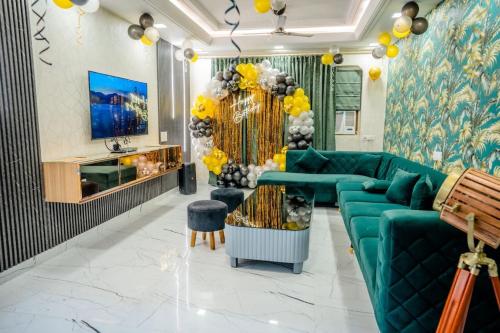 a living room with a green couch and yellow decorations at Rosset-57, Cosy Stay & luxury party place in Faridabad