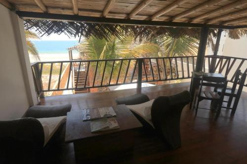 a balcony with a table and chairs and the beach at Makani Vichayito in Vichayito