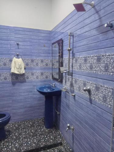 a blue bathroom with a sink and a mirror at New Gama Guest in Polonnaruwa
