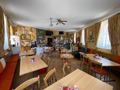 a restaurant with tables and chairs in a room at Penzion Manderlak in Liptovský Mikuláš
