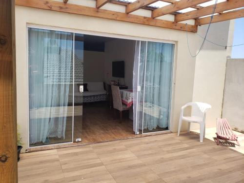 eine Glasschiebetür zu einem Zimmer mit einem Tisch in der Unterkunft Apartamentos de Verão in Tramandaí