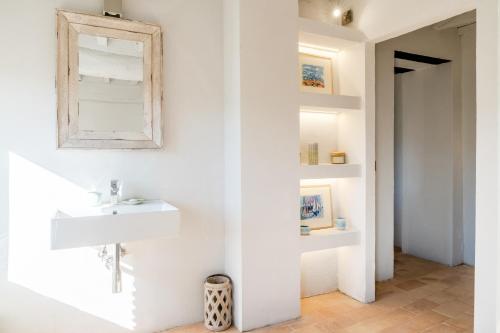 a white bathroom with a sink and a mirror at CASALE ORTALI - Miani Group in Pesciano