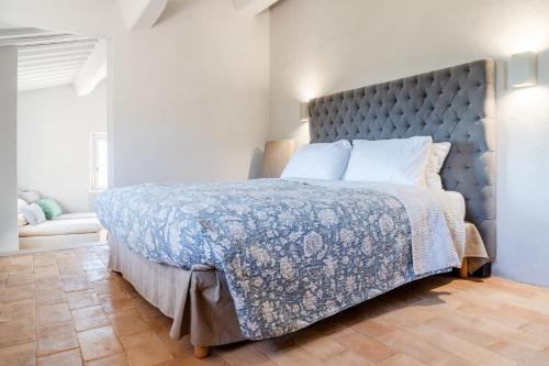 a bedroom with a large bed with a blue comforter at CASALE ORTALI by Miani Group in Pesciano