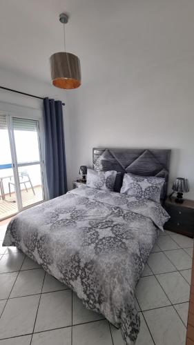 a bedroom with a bed with a gray comforter at Apartamento Vista Mar in Martil