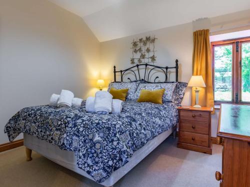 um quarto com uma cama com almofadas azuis e amarelas em 2 Bed in Fowey LTBUZ em Cardinham