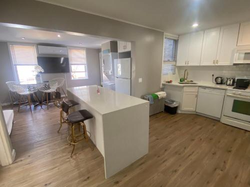 uma cozinha com uma grande ilha branca num quarto em Peaceful House near Manhattan em Queens