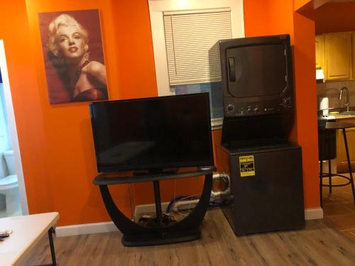 une télévision assise sur une table à côté d'un réfrigérateur dans l'établissement Peaceful House near Manhattan, à Queens