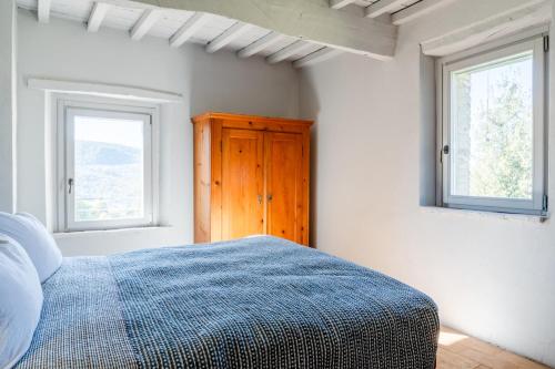 a bedroom with a bed and two windows at CASALE ORTALI by Miani Group in Pesciano