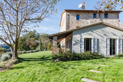 an old stone house with a grass yard at CASALE ORTALI by Miani Group in Pesciano