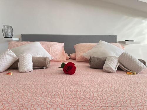 uma cama com uma rosa vermelha em cima em Tramonti In Santa Marinella em Santa Marinella
