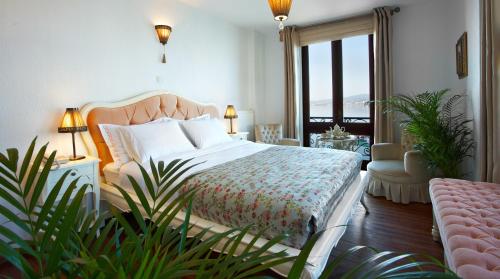 Habitación de hotel con cama y balcón en Ferahi Evler Hotel, en Ayvalık