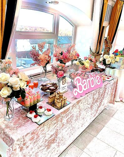 a buffet with desserts and flowers on a table at The Continental Hotel, Derby in Derby