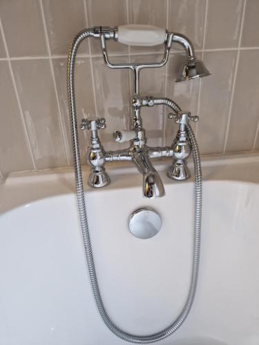 a shower head on top of a bath tub at Beach Apartment, Hunstanton Norfolk in Hunstanton