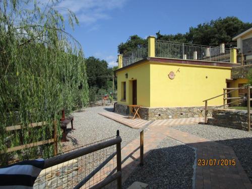 a yellow house with a fence in front of it at Agriturismo Rio Castello in Marina dʼAndora