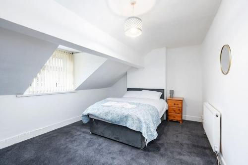 Habitación blanca con cama y ventana en Large 5 bedroom town house in Edgbaston, 2 kitchens en Birmingham