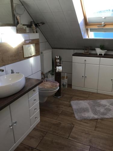 uma casa de banho com um lavatório branco e um WC. em Apartment Eichwald em Sexau