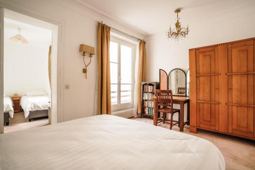 um quarto com uma cama, uma secretária e uma janela em Apartment in Rue Saint-Honoré em Paris