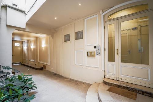 um corredor vazio com uma porta e uma planta em Apartment in Rue Saint-Honoré em Paris