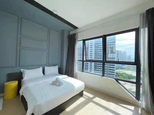 um quarto com uma cama branca e uma grande janela em KL City Family Suite Level38 em Kuala Lumpur