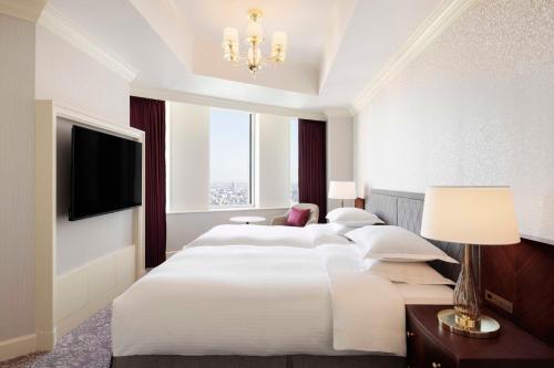 a large white bedroom with a large bed and a chandelier at Nagoya Marriott Associa Hotel in Nagoya