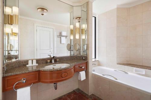 a bathroom with a sink and a tub and a mirror at Nagoya Marriott Associa Hotel in Nagoya