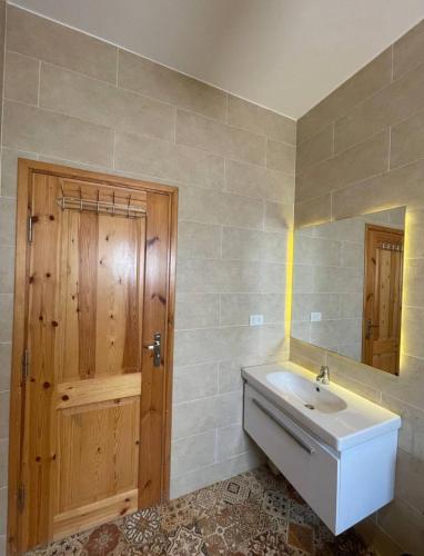 a bathroom with a sink and a wooden door at Casablanca1 in Dahab