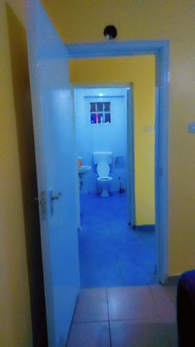 uma casa de banho com um WC branco num corredor em Nabbynates homes em Eldoret