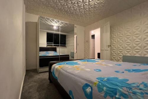 - une chambre avec un grand lit orné de fleurs bleues dans l'établissement Charming 2Bedroom Retreat in Great Barr/Hamsted, à Birmingham