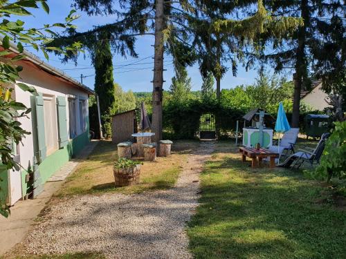 un patio con una casa, una mesa y sillas en Koppány Pines Rewild Escapes - The Lodge, en Koppányszántó