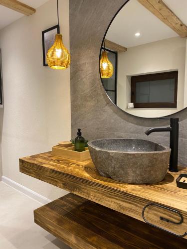 a bathroom with a stone sink and a mirror at Mountain Chalet - Cabana la Muntele Baisorii in Muntele Cacovei