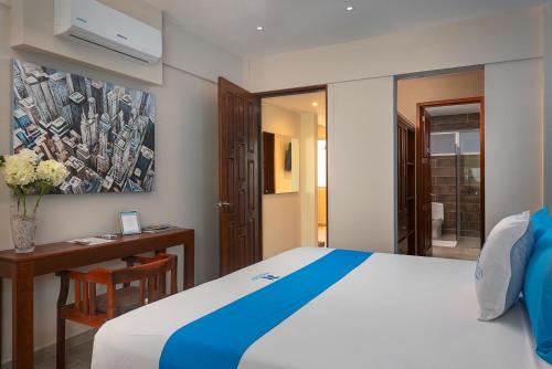 a bedroom with a bed and a desk and a painting at Blue Veleta in Tulum